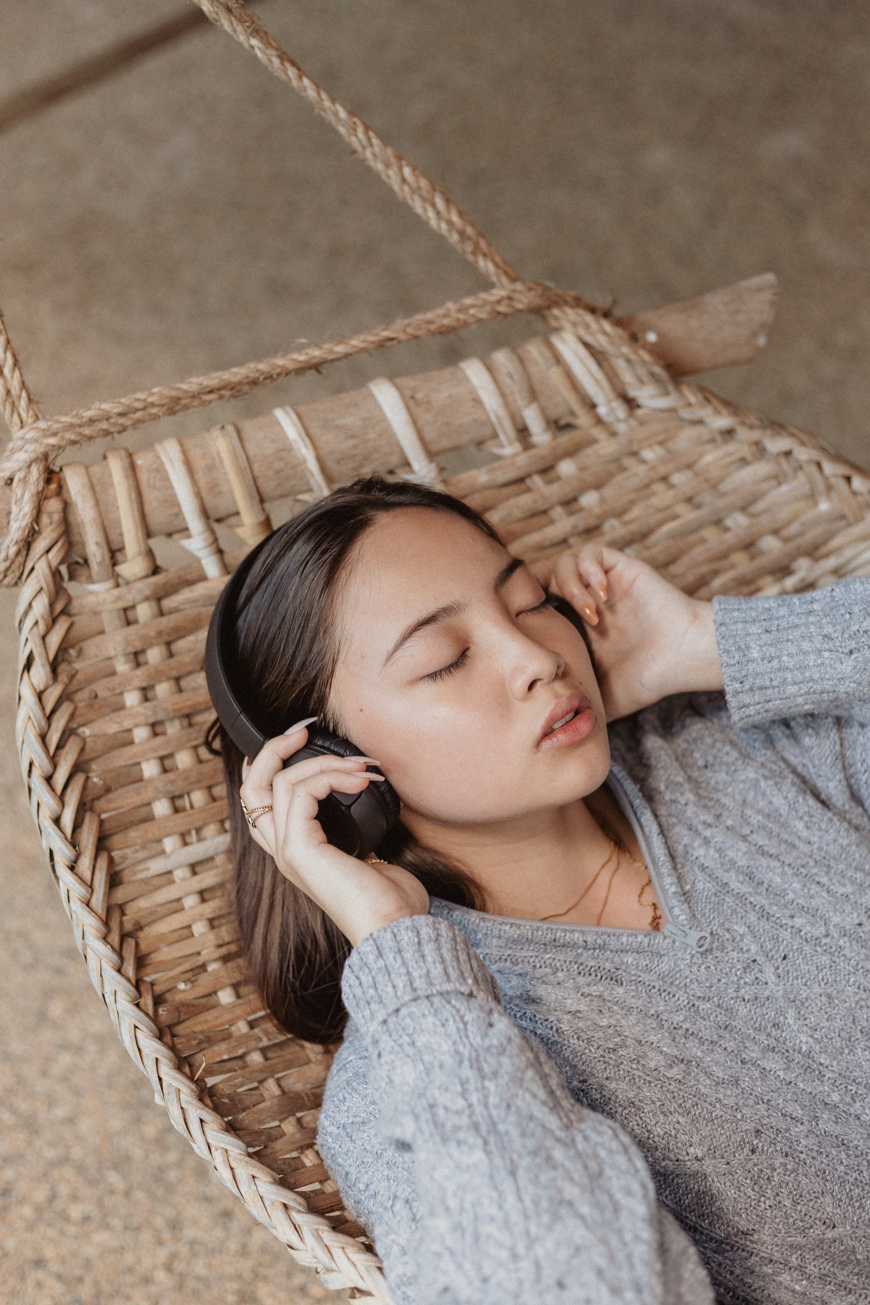 Woman on Hammock Listening to Music with Headphones